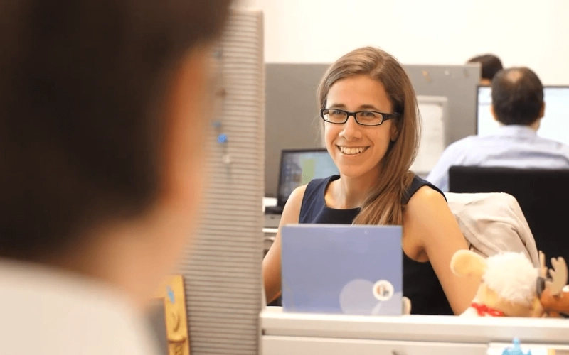 Employee of the Actuarial Department sits smiling at her workplace (Video Still)