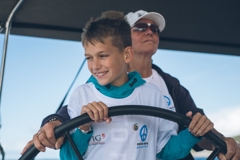 Child pilots a boat of the peace fleet mirno more together with an adult